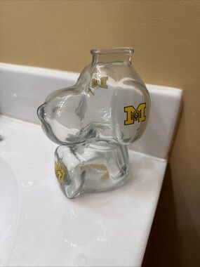 Clear Glass snoopy bank with university of Michigan logo